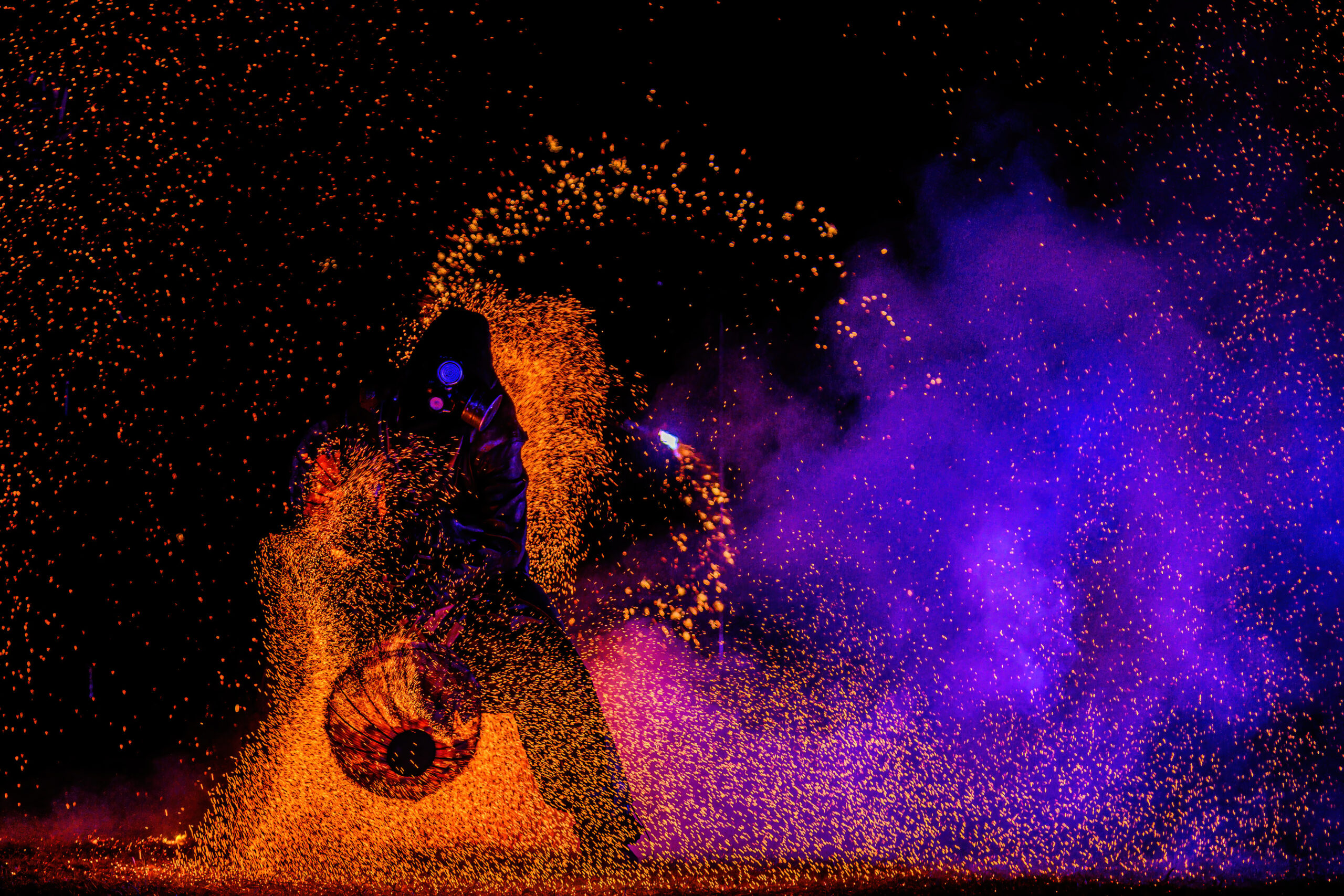 Fire PFC Artista inmerso en una nube de ascuas durante una actuación de fuego y carbon, creando un espectáculo impactante y mágico de la compañia inspyra shows